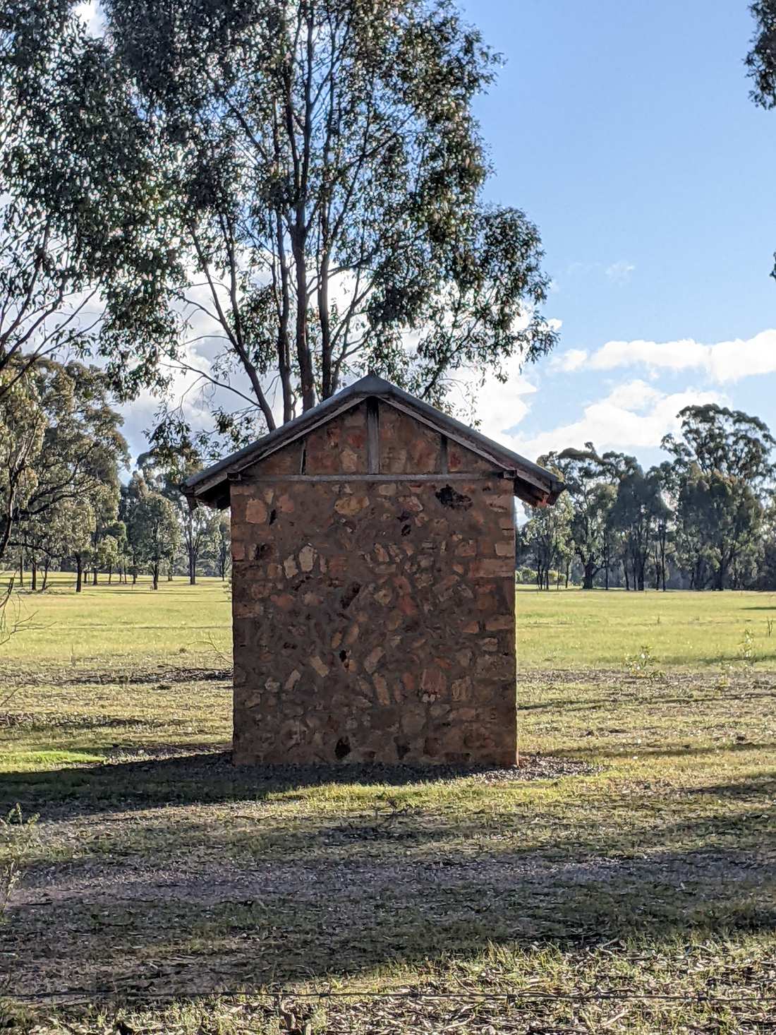 A lone stone structure standing in an open paddock near Murchison, Victoria.